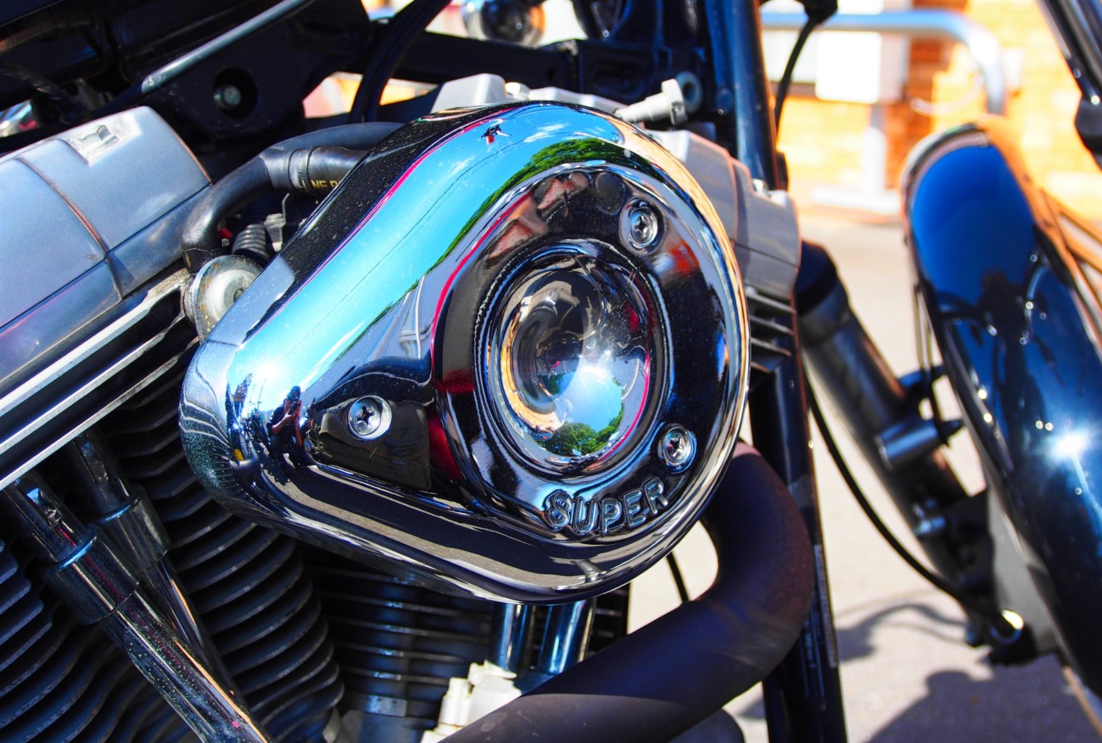 サビ防止スプレーでケアするバイクのメッキとボルトのクローズアップ